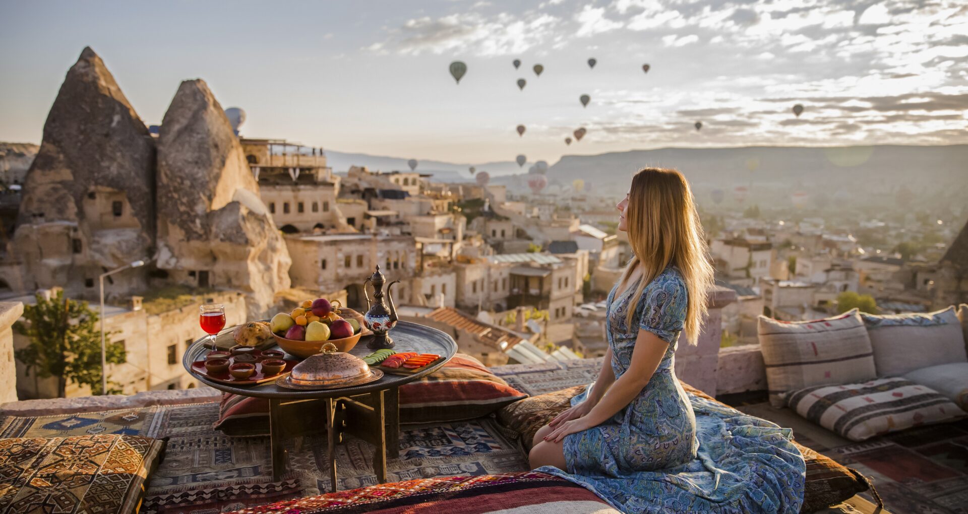 Une femme admirant les montgolfières et la vue en Turquie