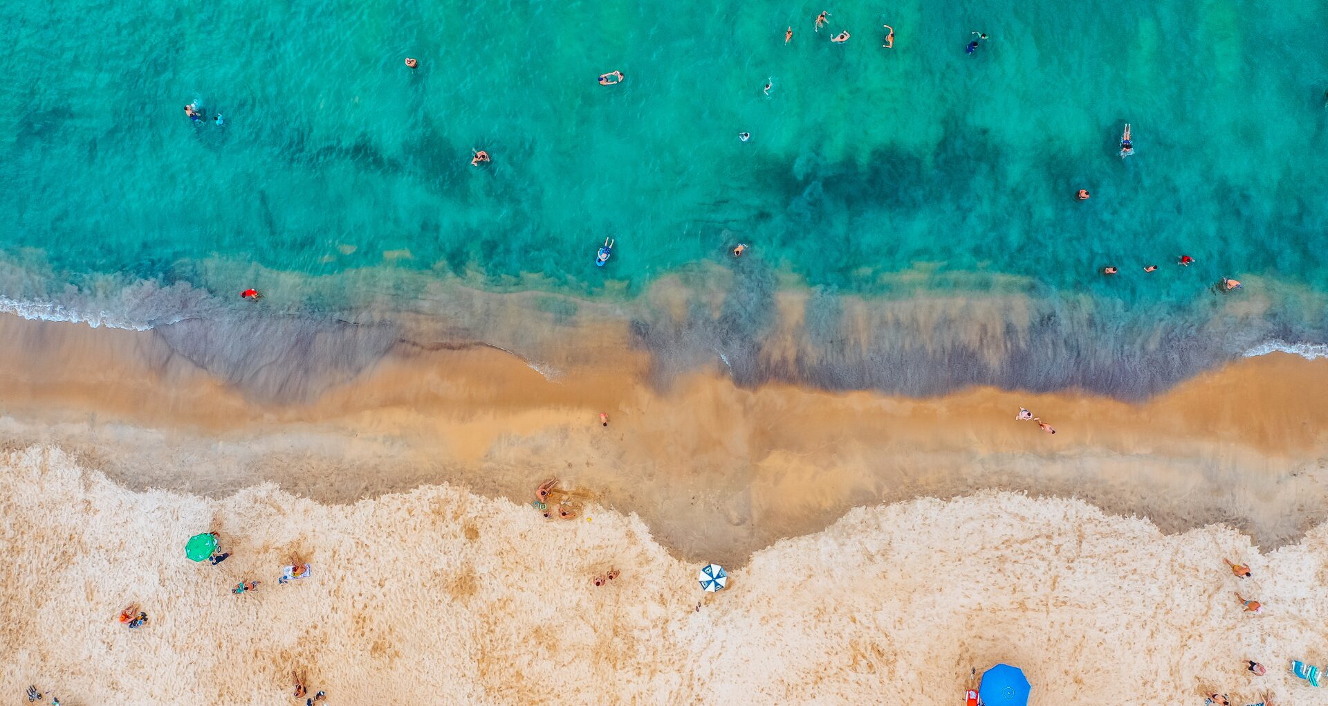 Une plage de sable et ses eaux turquoises vue du ciel