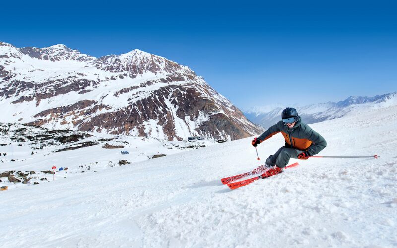 Un skieur dévalant les pistes de ski par un temps ensoleillé