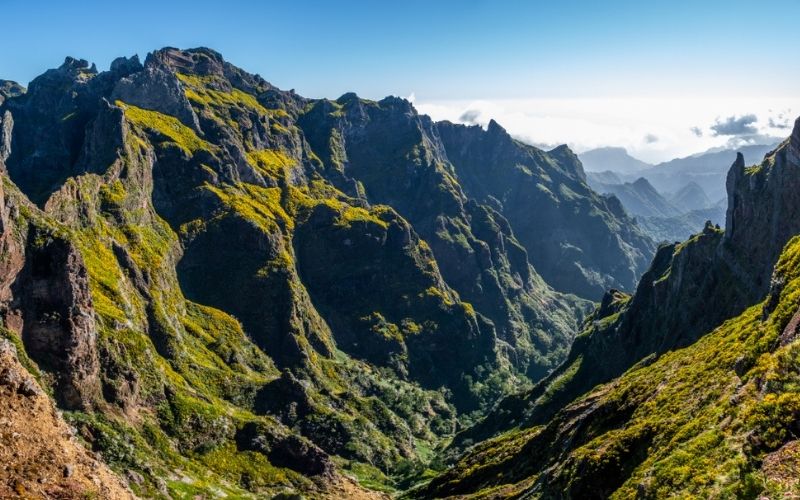 Uitzicht over ruige, groene bergen van Madeira en een strakblauwe lucht