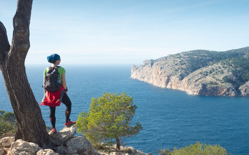 Une randonneuse regardant la vue sur la mer et la montagne sur l'île de Majorque.