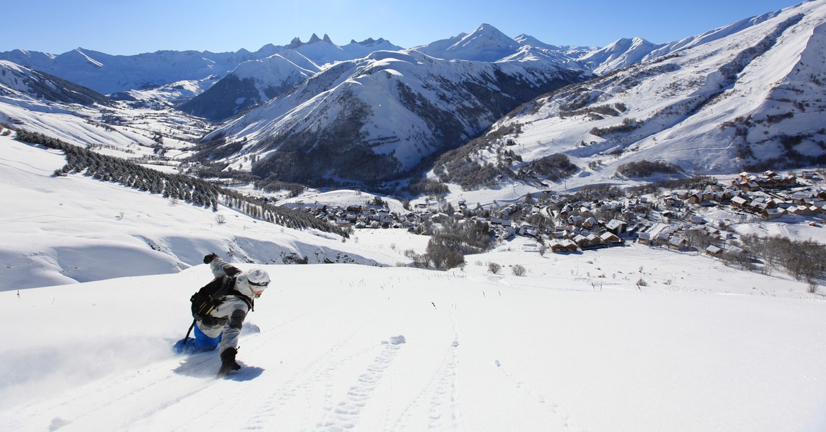 Kind skiet van de piste met uitzicht over de bergen