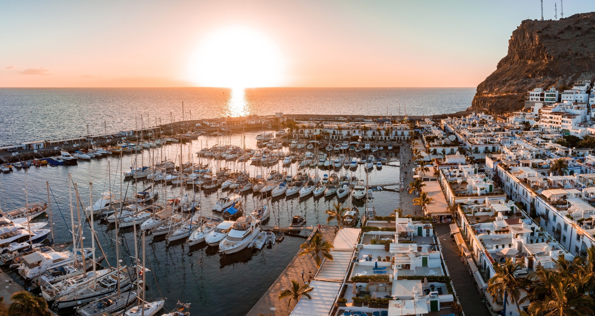 Uitzicht op de haven en de zee van Puerto de Mogán bij zonsondergang